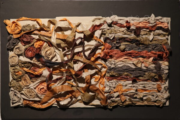 Strips of fabric interwoven to demonstrate the challenge of teasing apart data to construct a thematic understanding.